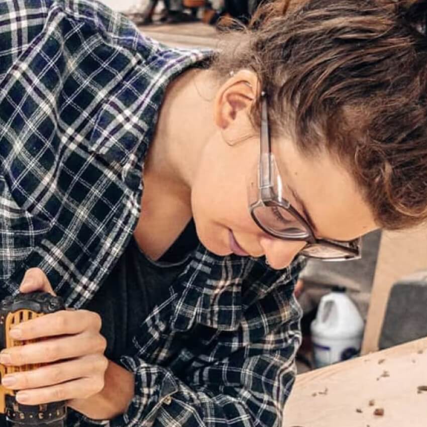 Person wearing safety glasses using a power tool while working on a project.