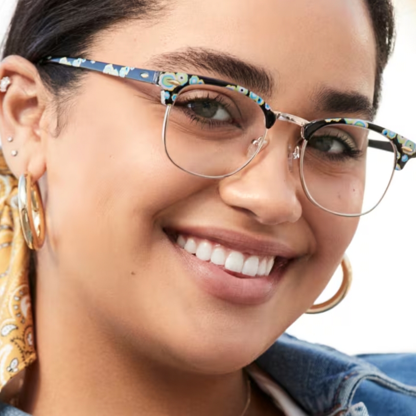 Eyeglasses with a colorful patterned frame and clear lenses worn by a person.