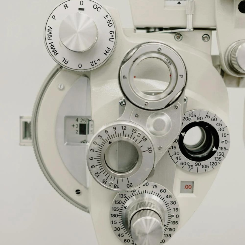 Optometry phoropter with dials and lenses for eye examination and vision testing.