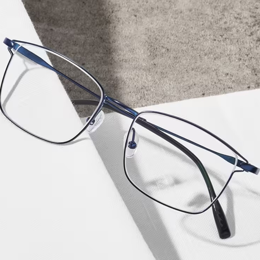 Rectangular blue metal eyeglasses with clear nose pads and thin black temple tips.
